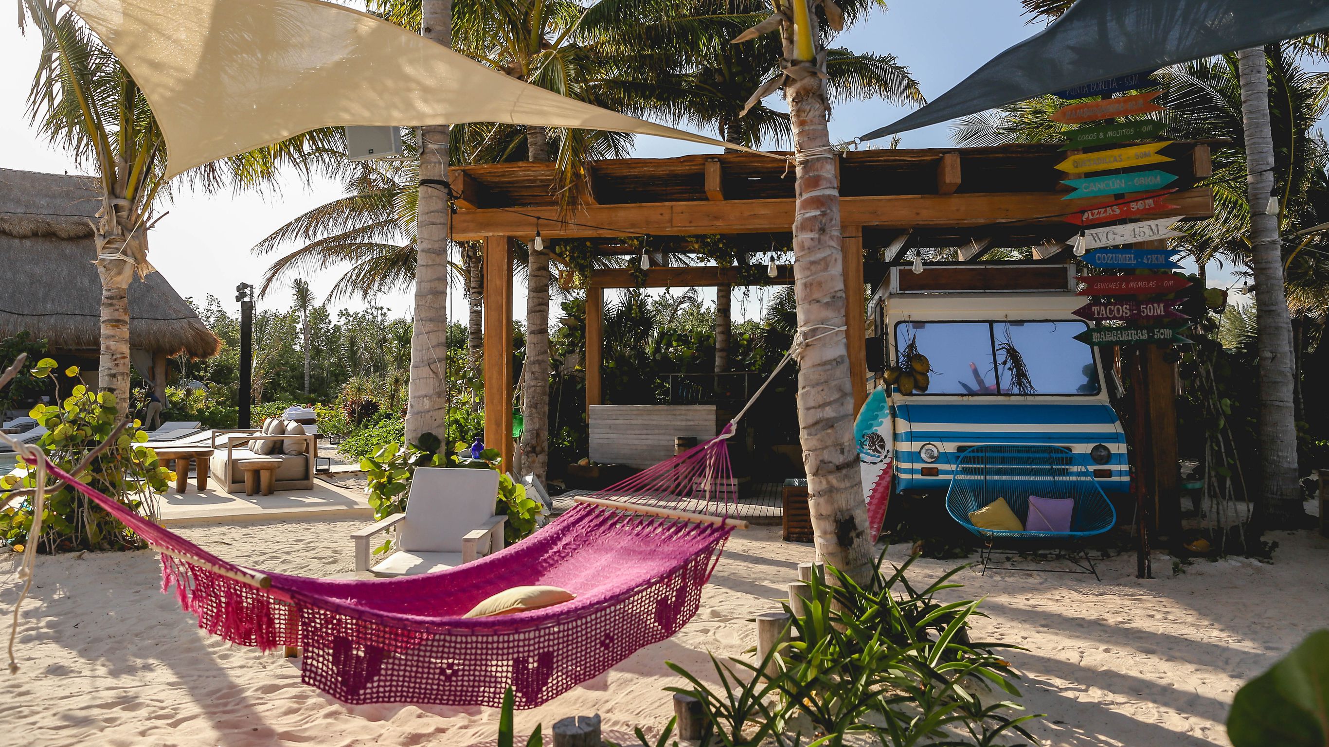 配有粉色吊床和 La Cantina 餐车的 Aquí Me Qudeo 餐厅休息区